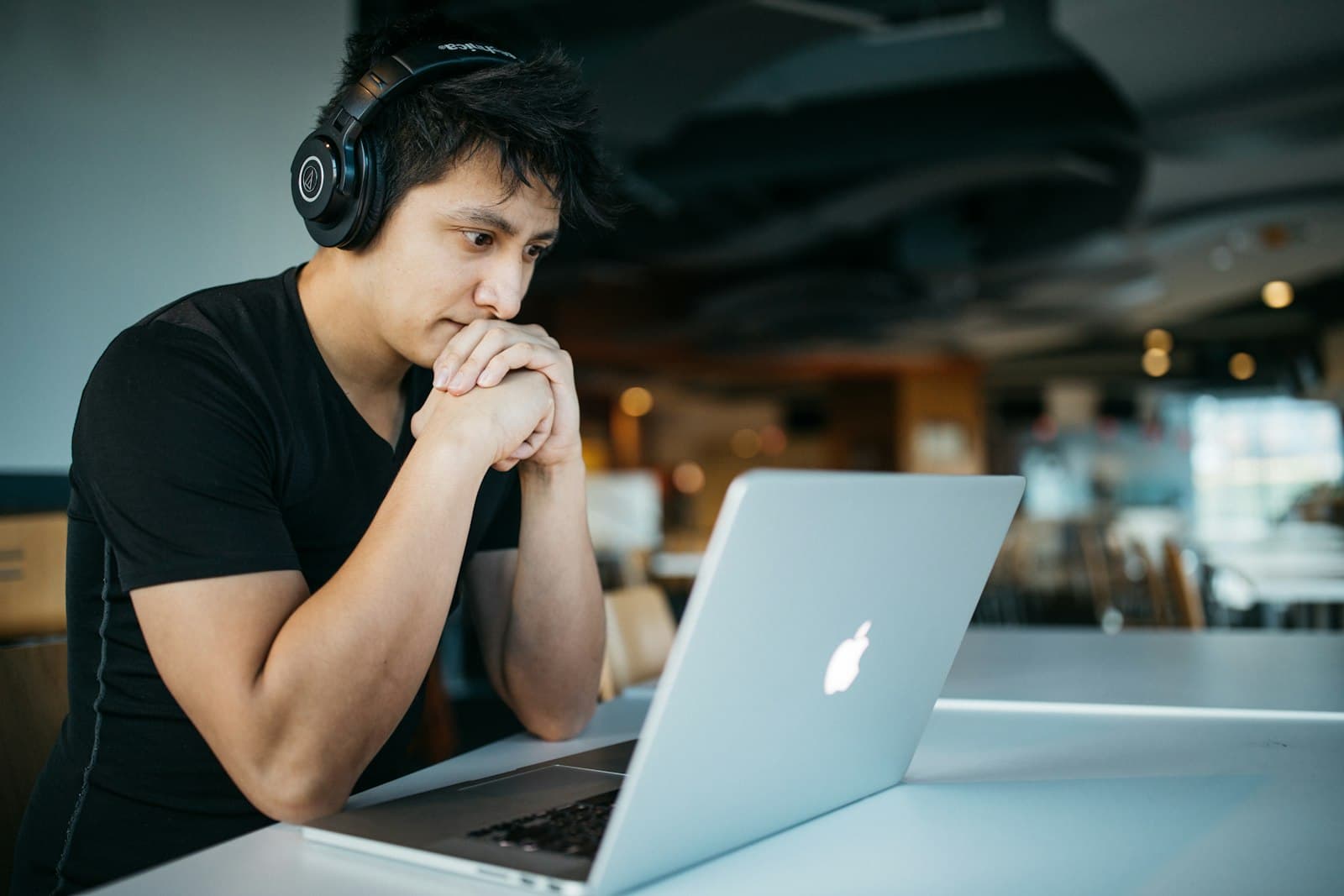 A learner with headphones following a lesson on his laptop